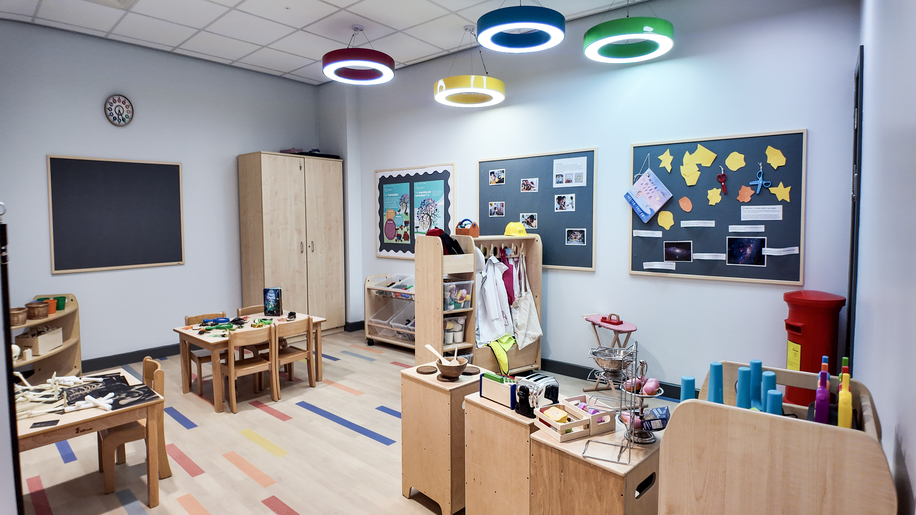 Role-play and creative learning area with dress-up, a play post office and pinboard displays